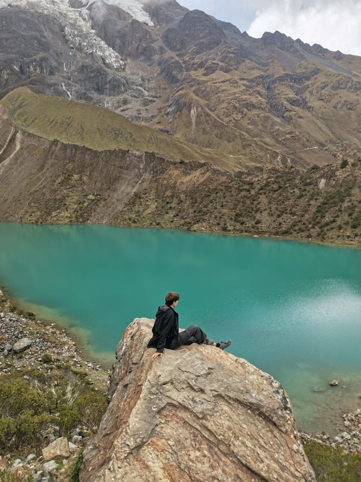 Sitting on the rocks at the shore of Humantay lake